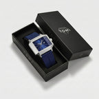 Blue watch with silver case in an open black box on a light gray background